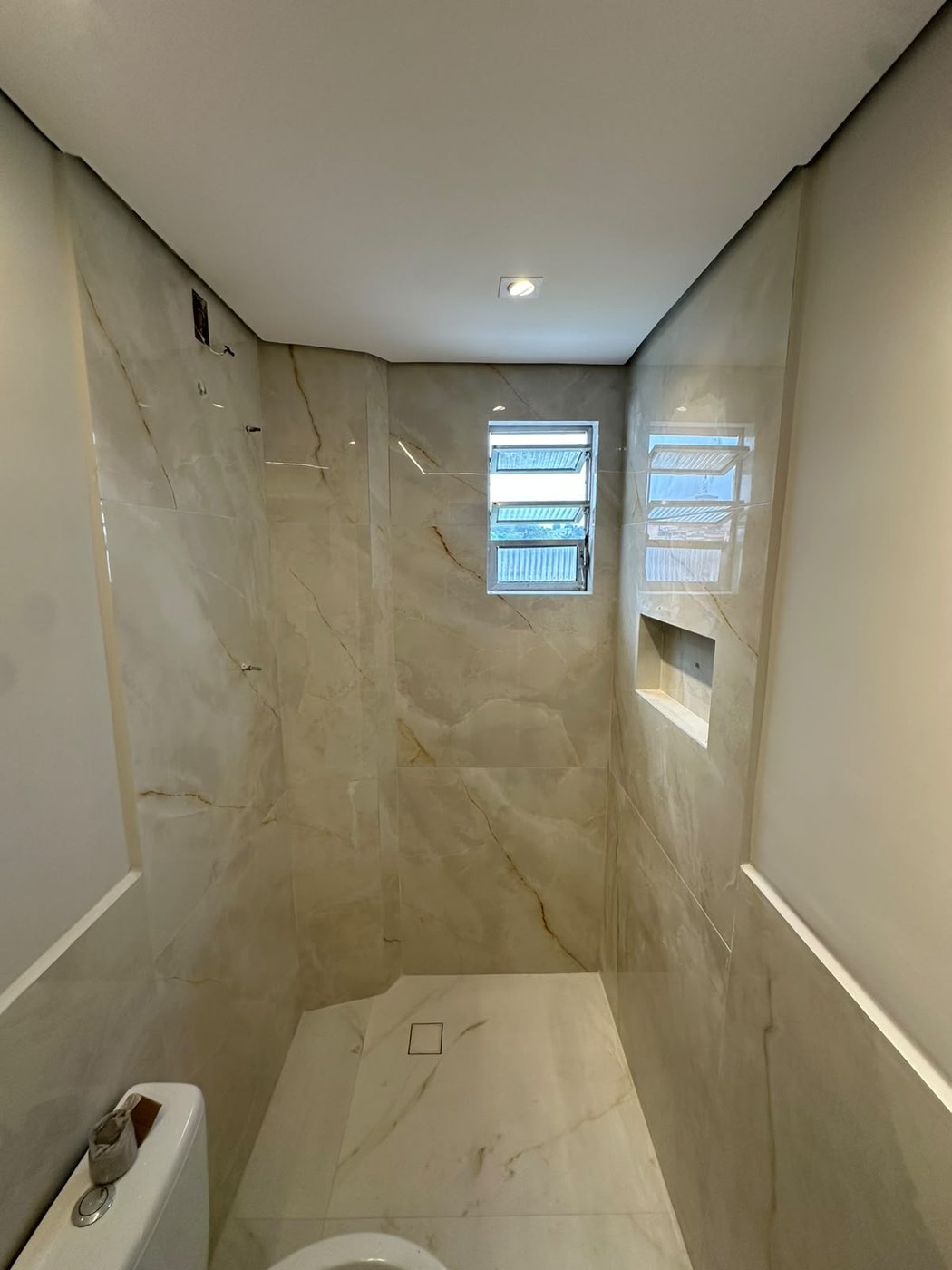Box de banheiro revestido em porcelanato do piso ao teto